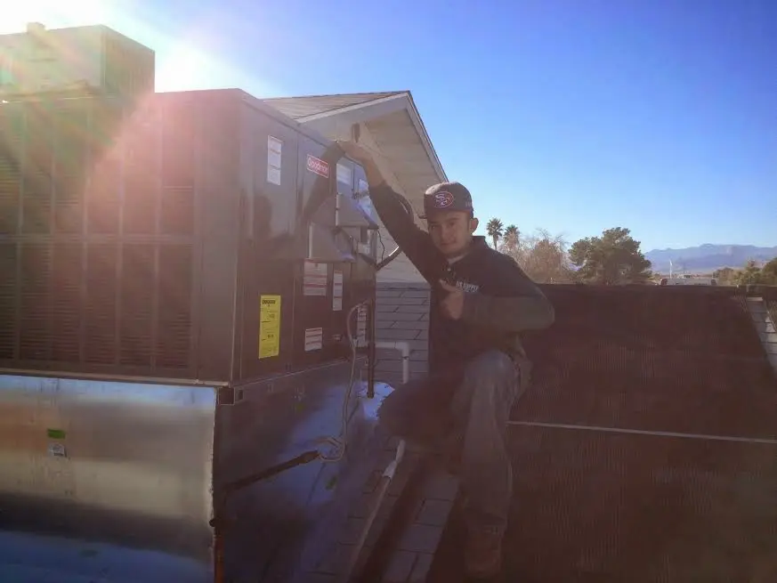 HVAC technician performing Air Duct Repair on a rooftop unit in Midway City